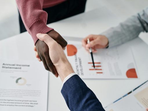 Professional handshake over financial documents symbolizes successful business partnership and teamwork.